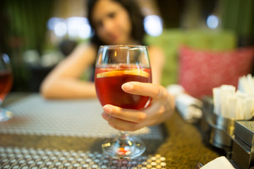 A girl drinks a red strawberry drink in a restaurant