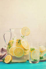 Lemonade homemade drink - jar and glasses on table, retro toned