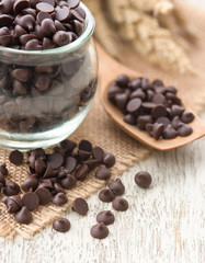 Dark chocolate chips on wood background.