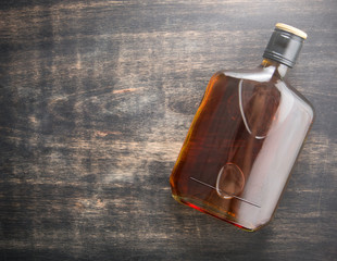 Bottle of whiskey on wood