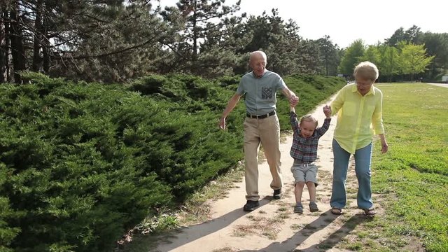 Grandparents lifting up toddler boy outdoor