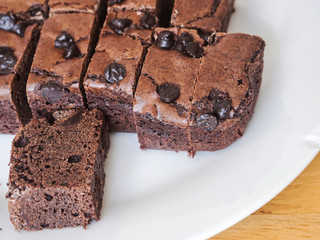 Brownies chocolate cake with plastic fork on white dish