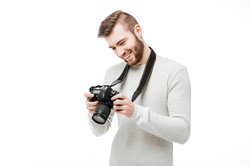 Happy young man watching through photos on camera display isolated