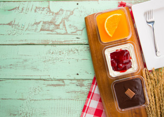 chocolate cake orange cake and strawberry cake in plastic cup on wood table