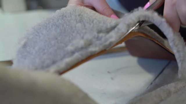 Close-Up of Hands of a Young Girl With Scissors Cut the Edge of the Faux Fur is Sewn to the Leather Along the Workpiece to Women's Boots of the Castle