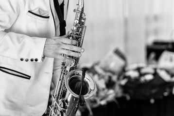 Saxophonist in white jacket plays the saxophone. Saxophonist jazz man with saxophone on wedding...