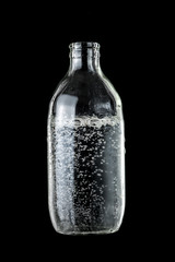Bottle of sparkling water over dark background