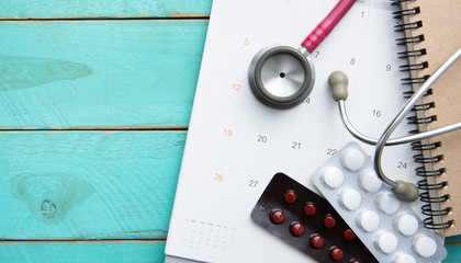 stethoscope and drugs on calendar, medical concept