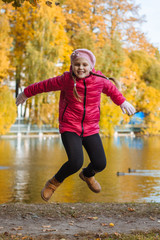 Happy little child, baby girl laughing and playing in the autumn on the nature walk outdoors