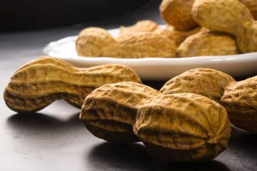 Peanuts in shell on dark background, close up