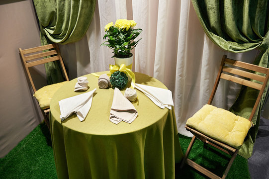 Table, chairs and bouquet of yellow flowers in vintage interior