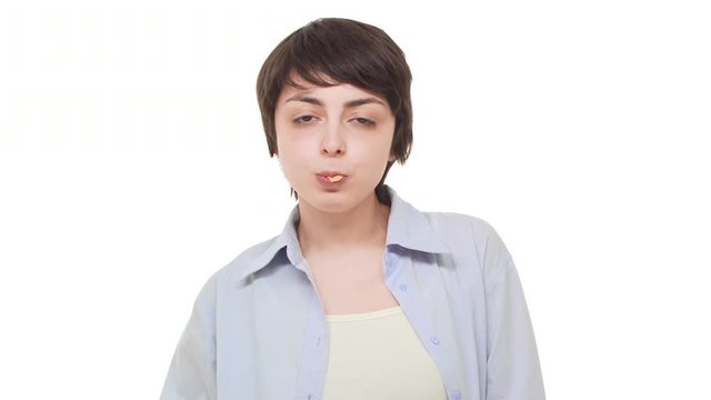 Young Caucasian girl with brunette short hair chewing gum and blowing bubble over white background