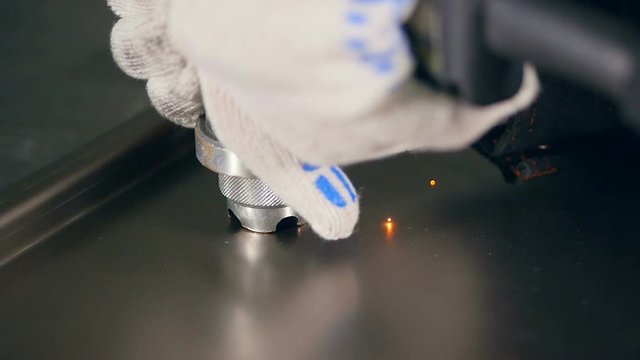 Worker using industrial riveter on metal. Slow motion.