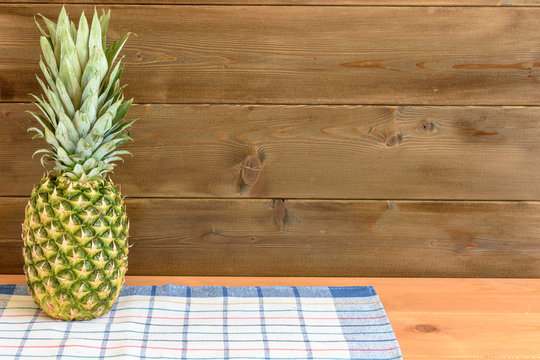 Ripe anans on a wooden table and background texture with free space for writing