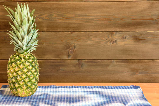 Ripe anans on a wooden table and background texture with free space for writing