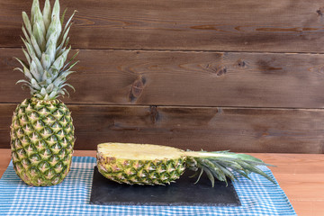 Ripe anans on a wooden table and background texture with free space for writing