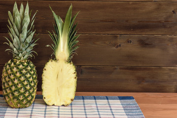 Ripe anans on a wooden table and background texture with free space for writing