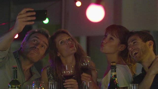 Friends drinking wine and posing for selfie