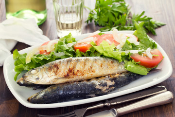 grilled sardines with salad on white dish