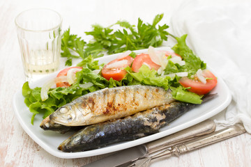 grilled sardines with salad on white dish