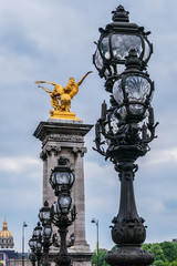 Fototapeta na wymiar Sculpture on Alexandre III bridge. The bridge, with its exuberant Art Nouveau lamps, cherubs, nymphs and winged horses at either end, was built between 1896 and 1900. Paris, France.