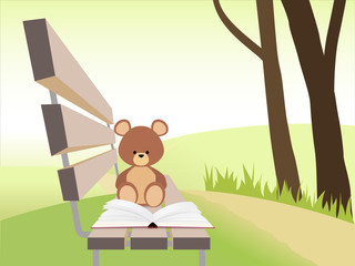 Open book and bear toy on bench at sunset park. Nature background.