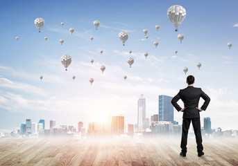 Motivation and inspiration concept with modern cityscape and businessman observing it