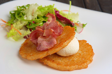 Traditional russian draniki with bacon and salad