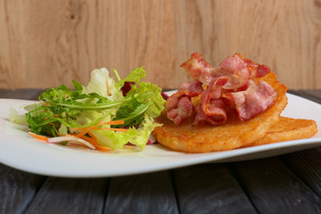 Traditional russian draniki with bacon and salad