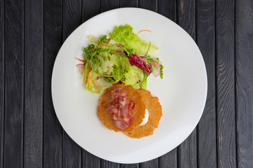 Traditional russian draniki with bacon and salad. Top view.