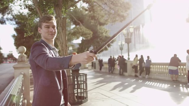 Young man is taking a selfie on a sidewalk while spinning round