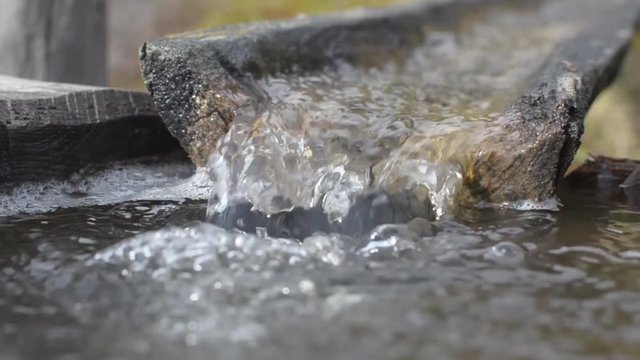 Water flowing in old wooden groove