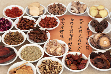 Traditional chinese herbal medicine selection in porcelain bowls with calligraphy script. Translation describes the medicinal functions to maintain body and spirit health and balance energy.