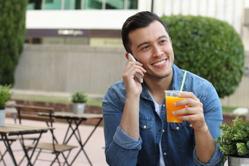 Fototapeta premium Man calling by phone while enjoying a nice drink outside