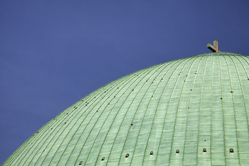 Obraz premium Massive green dome with a christian cross on top of Hedwig's Cathedral in Berlin Mitte.
