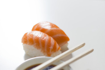 Sushi. Salmon niguiris on white background with chopsticks and soy