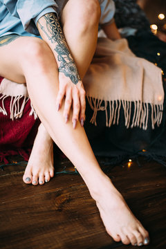 Beautiful woman with dreadlocks and tattoos. Legs and arms closeup. Boho style