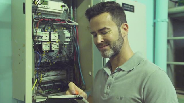 Electrician Checking Electric Control Cabinet