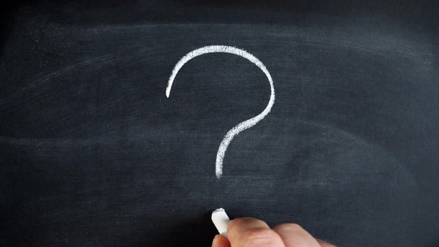 Male hand drawing question mark on chalkboard. Making decision, seek a solution concept
