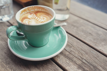 cup of coffe latte art on wooden table