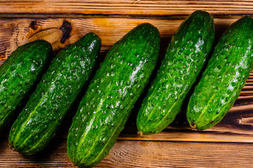 Ripe tomatoes and cucumbers on wooden table. Top view