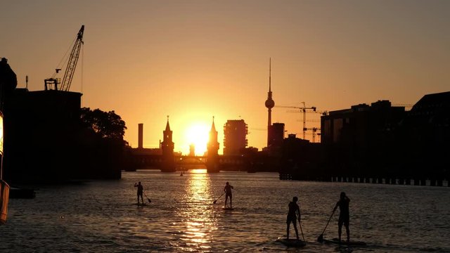 Sunset sky Berlin Panorama - river Spree, Oberbaum Bridge, Tv Tower and stand up paddle board people 