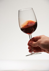 One hand hold red wine glass