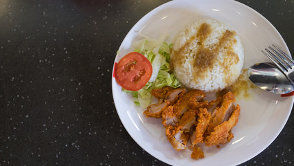 Fried chicken with steamed rice with dressing sauce and slice tomato and cabbage