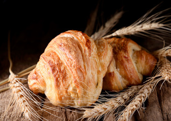 Tasty croissants on wooden background.