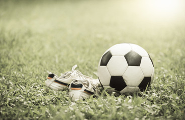 football on grass and stud shoe on vintage tone