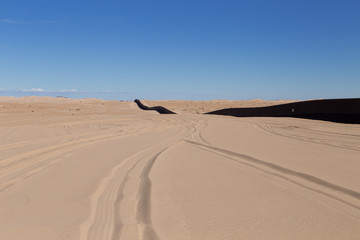 Fototapeta na wymiar U.S. / Mexico border wall stretching along Imperial Sand Dunes