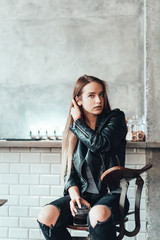 Fototapeta na wymiar Beautiful girl in a black jacket in a cafe