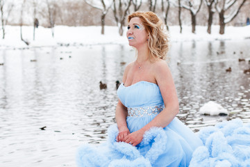 Fototapeta na wymiar Woman in a beautiful blue dress in a winter