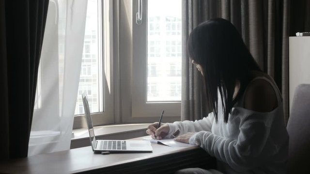 Woman writing at laptop